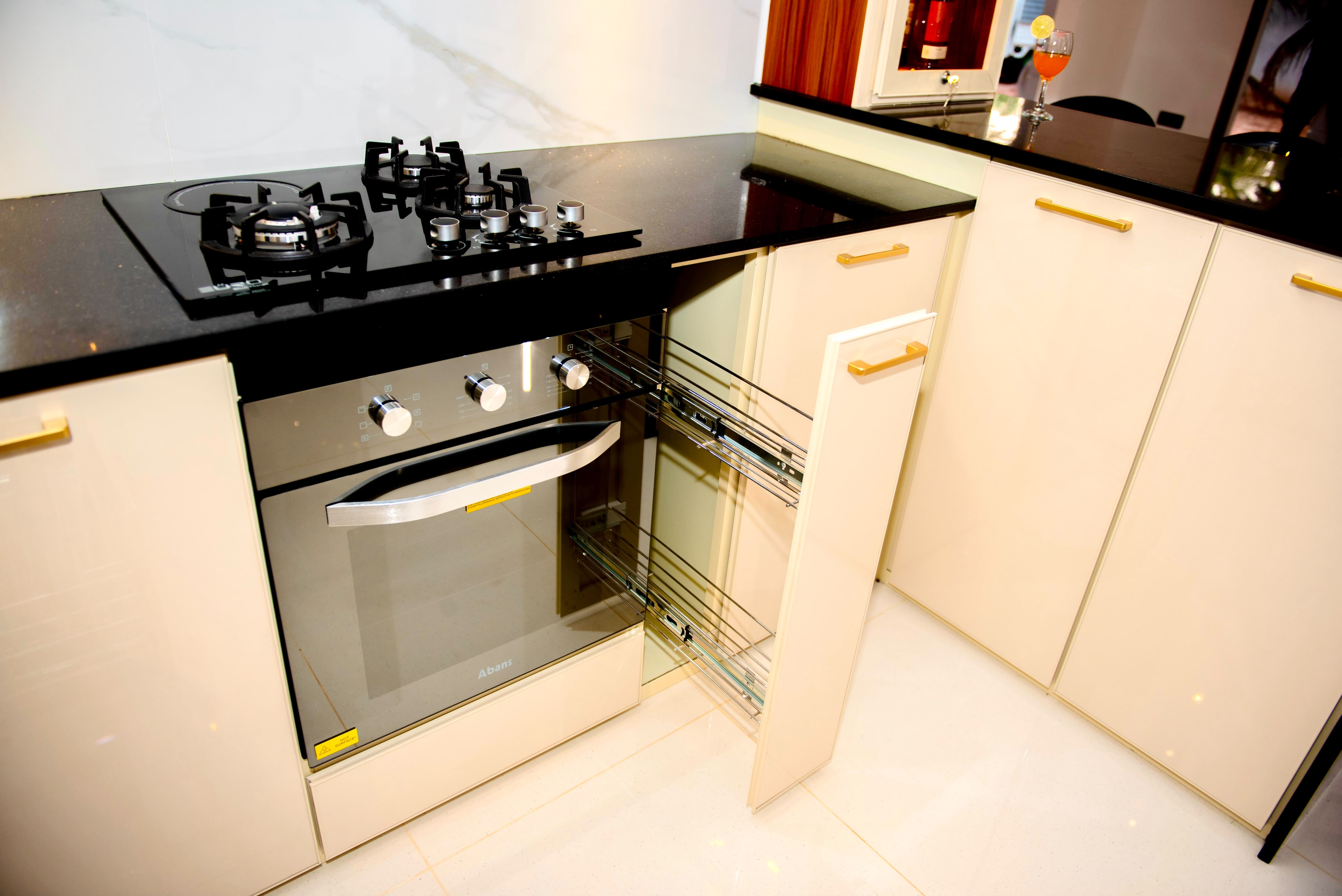 Cream kitchen cabinets with built-in oven and pull-out drawers